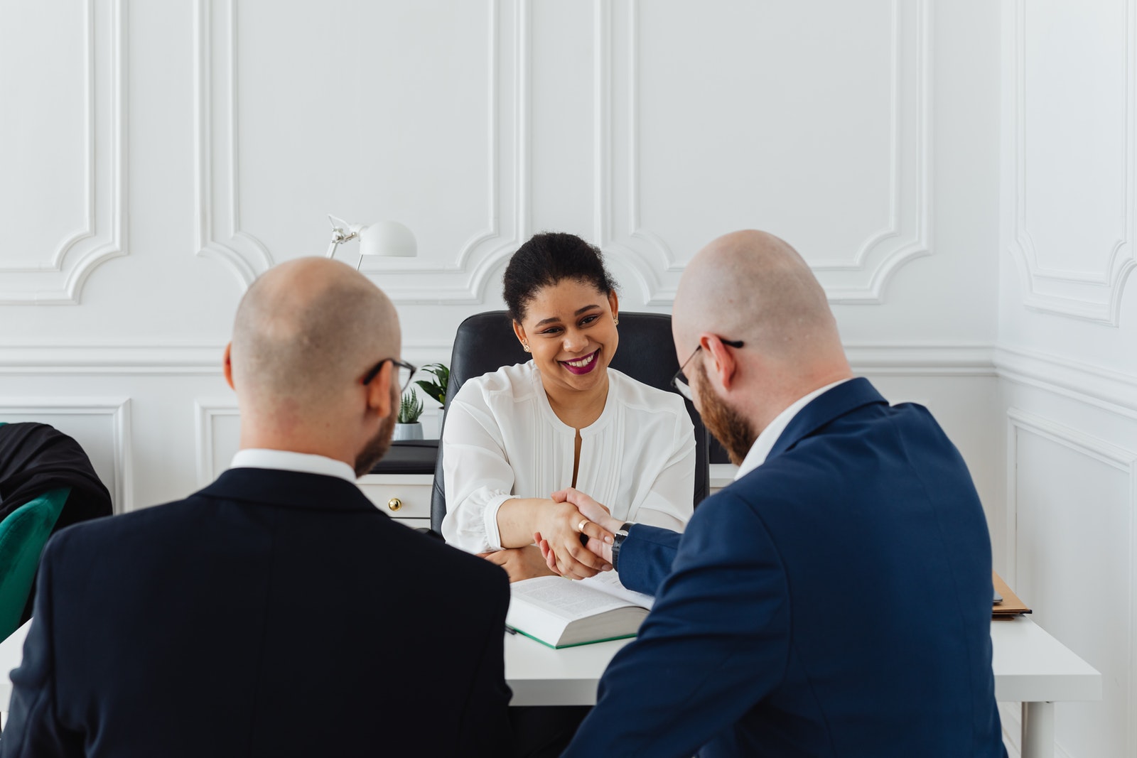 A female lawyer meets with two marketing agency representatives
