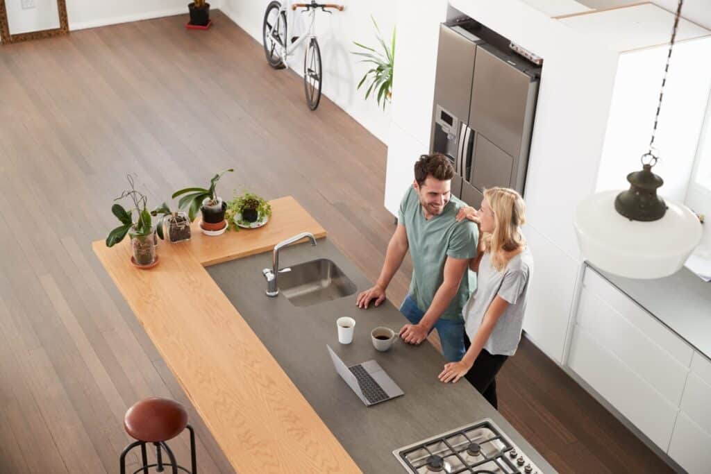 Young couple stand in their new luxury apartment kitchen