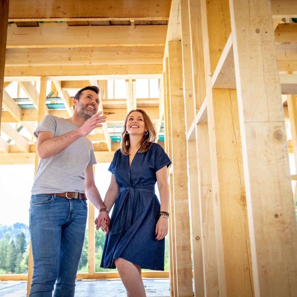 Couple tours homebuilding construction site.