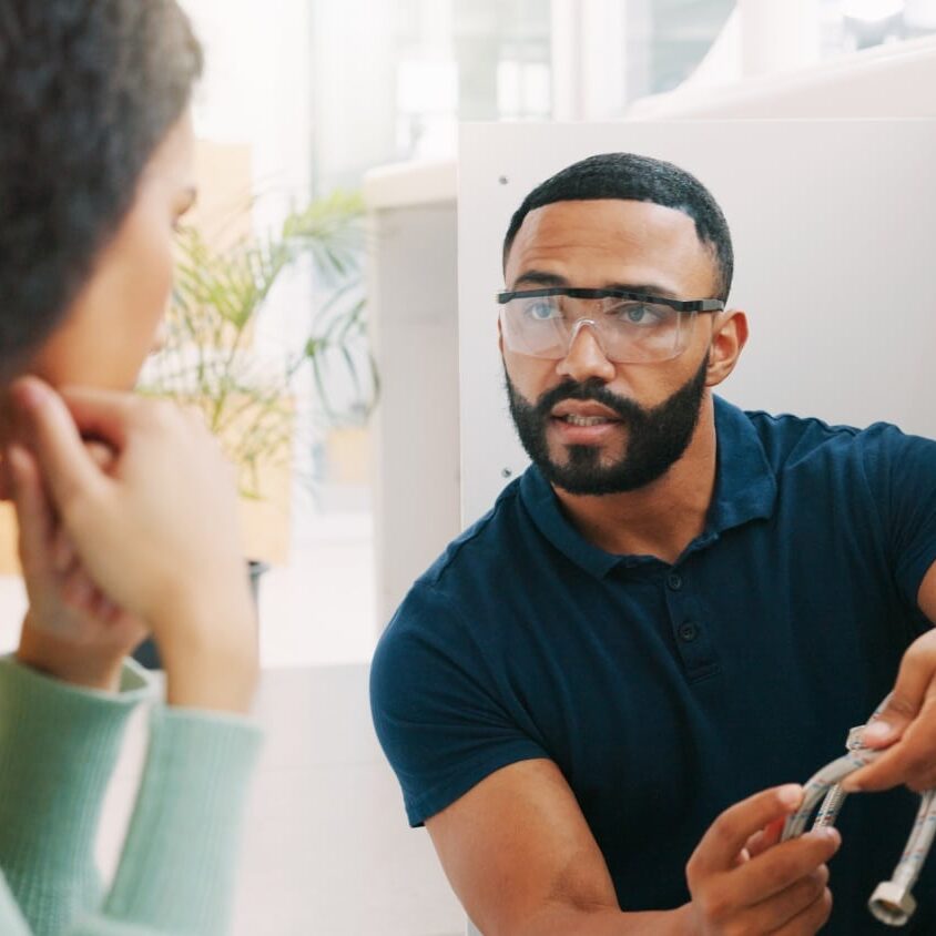 A plumber talks to a homeowner